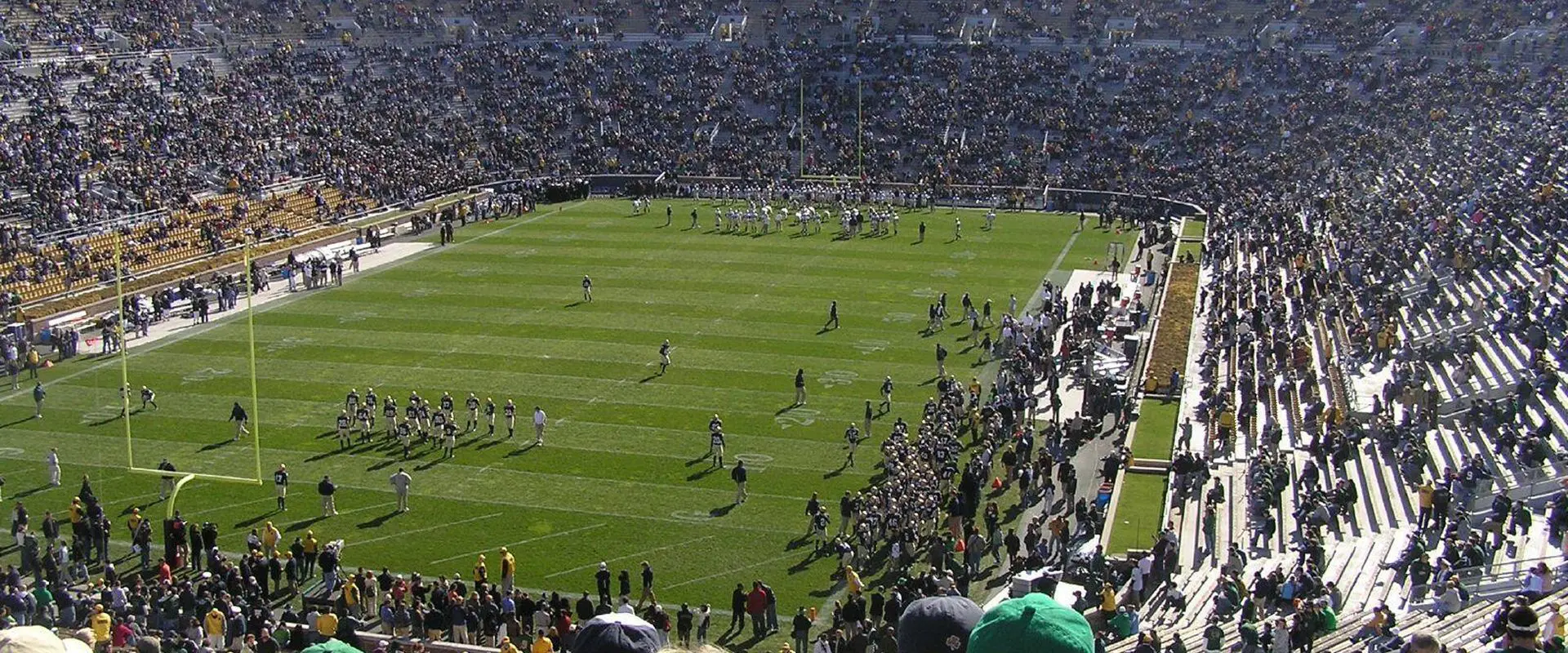 Football stadium with players and crowd.