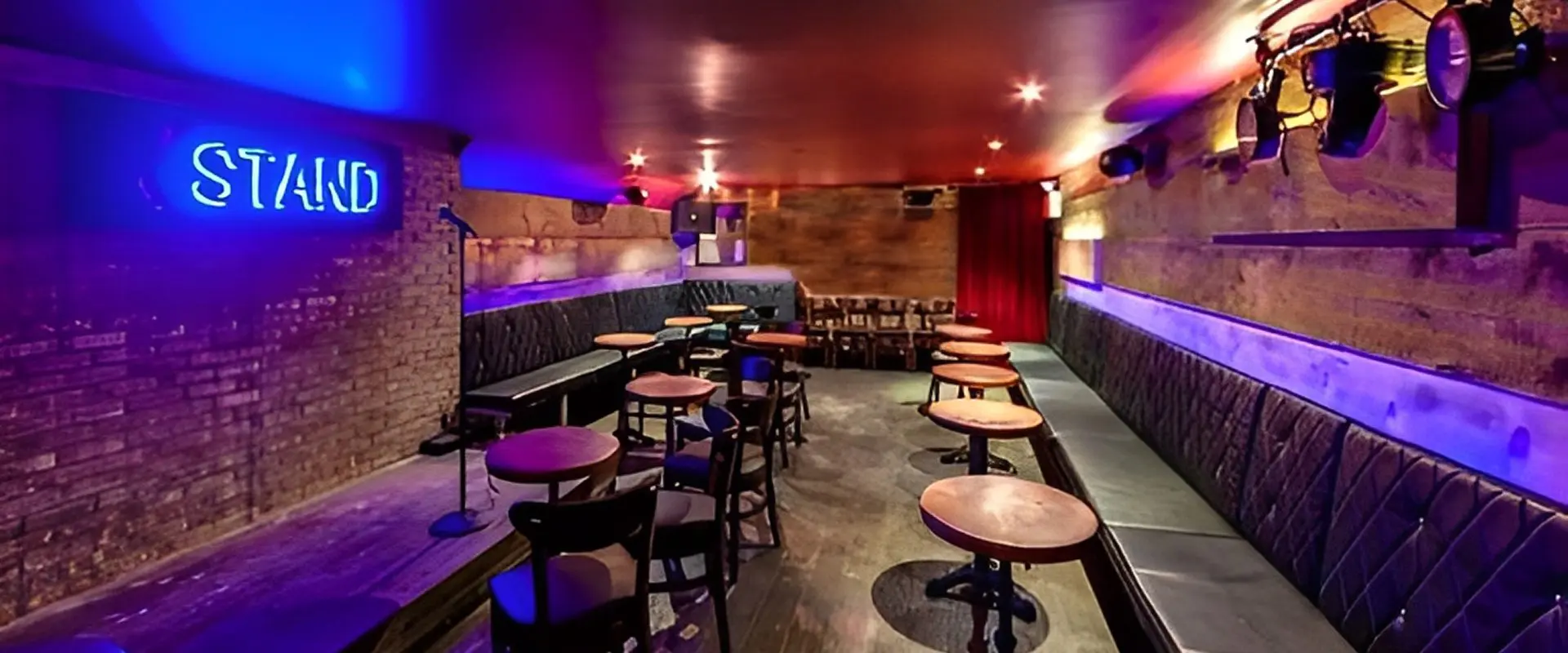 Empty comedy club with stage and seating.