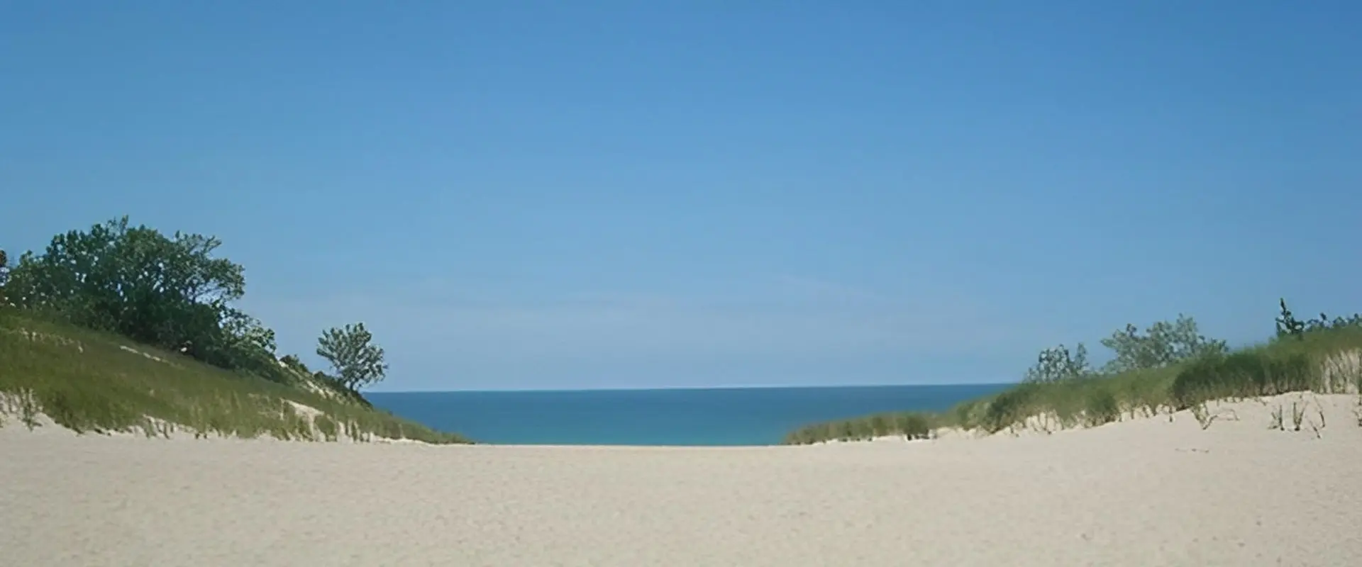 Sandy beach path leading to ocean.
